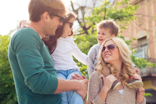 Young happy family walking outdoor with shopping bags.